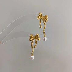 two pairs of earrings with bows and pearls