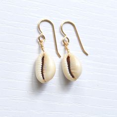 Simple & cute describe these whole cowrie shell earrings! They're the perfect accessory to wear with your favorite casual outfit when you're out & about. Please allow for variations in size and shape of shells as each is unique. Casual Shell Jewelry Gift, Handmade Cowrie Shell Earrings For Gift, Handmade Cowrie Shell Earrings As Gift, Casual Cowrie Shell-shaped Jewelry, Handmade Casual Shell Jewelry, Casual Handmade Shell Jewelry, Cowrie Shell Dangle Earrings As Gift, Gold Cowrie Shell Earrings As Gift, Gold Cowrie Shell Earrings For Gift