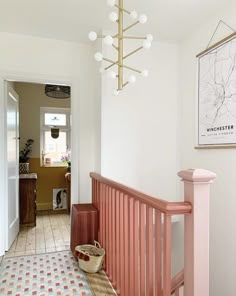 the hallway is painted pink and has a basket on the floor next to the railing