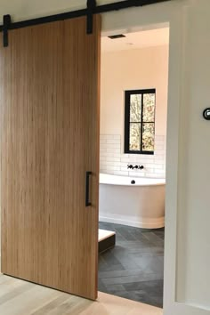 an open door leading to a bathroom with a tub