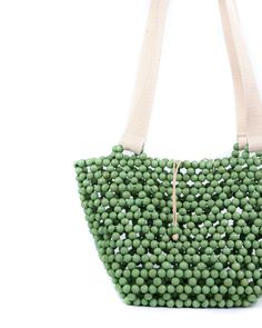 This is probably the bag you didn't know you needed—our take on the undeniably reliable tote bag. Imagine beachside or on the go in the city, the Riki basket bag will carry everything you need. Composition: Handmade Wood beads Bead slide closure Canvas straps Dimensions: 31cm x 15cm x 18cm (LxWxH) Green Satchel For Summer Beach Outings, Green Tote Satchel For Beach, Green Summer Travel Satchel, Eco-friendly Tote Bag With Top Carry Handle, Summer Hobo Bag With Removable Pouch, Green Top Handle Bucket Bag For Travel, Green Top Handle Vacation Bag, Green Pouch Satchel For Summer, Everyday Summer Top Handle Bag