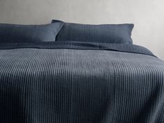 a bed with blue sheets and pillows on it