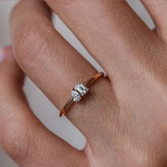 a woman's hand with a diamond ring on top of her finger and an engagement band