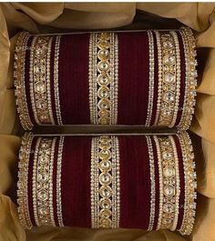 two red and gold pillows in a box