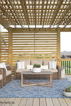 an outdoor living area with wicker furniture and wooden pergolated roof over it