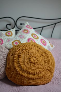 three crocheted pillows sitting on top of a bed