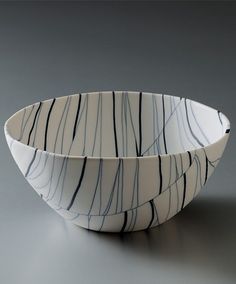 two white and black bowls sitting side by side on a gray surface with lines drawn across them