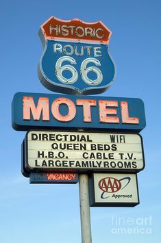 an old motel sign is shown against a blue sky