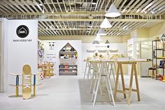 the inside of a store with various items on shelves and tables in front of it