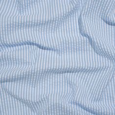 Evoking the easygoing lifestyle of a coastal New England town, this Wylie Light Blue and White Candy Striped Polyester and Cotton Seersucker is a sweet summer treat. The lightweight nature of seersuckers make them a functional fabric for warm weather climates; the puckered face feels cool on your skin as the easy drape catches the breeze. Often seen in stripes or checkers, this specific seersucker is lined with light blue and white candy cane stripes—a simple yet playful demonstration of color. Seersucker Aesthetic, Navy Mood Board, New England Town, England Town, Coastal New England, Italian Riviera, Candy Cane Stripes, Mood Fabrics, White Candy