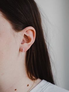 Delicate and dainty, the sterling silver chain attaches to both stud and post to create a unique hugged ear chain design - as unique and beautiful as the wearer.Material: Sterling silver. Hello Adorn makes beautiful minimalist everyday jewelry by hand in Eau Claire, Wisconsin. Everyday Sterling Silver Huggie Jewelry, Elegant Everyday Sterling Silver Piercings, Everyday Elegant Sterling Silver Piercings, Dainty Sterling Silver Huggie Earrings For Everyday, Elegant Sterling Silver Huggie Piercings, Everyday Dainty Sterling Silver Huggie Earrings, Sterling Silver Teardrop Huggie Earrings, Everyday Sterling Silver Pierced Cartilage Earrings, Minimalist White Gold Piercings