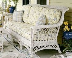 a white wicker couch sitting on top of a patio