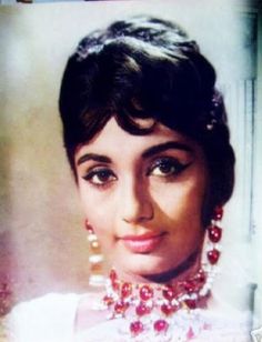 an old photo of a woman wearing a necklace and earrings with pearls on her neck