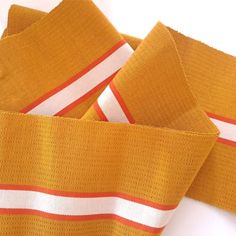 a narrow strip of woven fabric in bold colours Gold Aso Oke, Gold And Orange, Bag Fabric