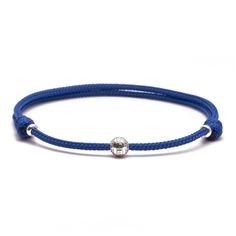 a blue cord bracelet with a silver ball on it