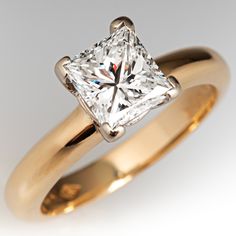 a yellow gold ring with a princess cut diamond