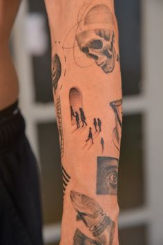 a man's arm with tattoos on it and people in the space around him