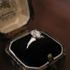 an antique diamond ring sits in its case