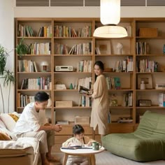 a man and child are sitting in front of bookshelves