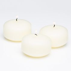 three white candles sitting next to each other