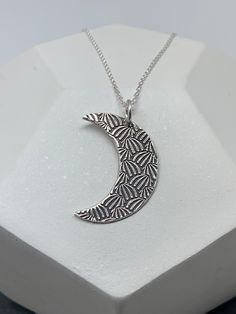 This unique silver moon necklace has been entirely handmade using .999 fine silver. It has been cut from fine silver precious metal clay, textured, fired and oxidized. The pendant hangs from a sterling silver diamond cut cable chain. This fine silver pendant features an embossed textured print pattern and hangs 1 1/4 from top of ring to bottom of the moon shape. Pendant size: approximately 1 x 3/4 inches Chain length: adjustable at 16 and 18 inches can also be customized to whatever length neede Boho Couches, Silver Moon Necklace, Moon Necklace Silver, Vertical Bar Necklace, Contemporary Necklace, Precious Metal Clay, Silver Moon, Sterling Silver Flowers, Moon Necklace