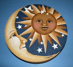 a painted sun and moon on the side of a blue sky with stars in it