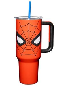 thermos cup with spiderman face on it is orange and has a black handle