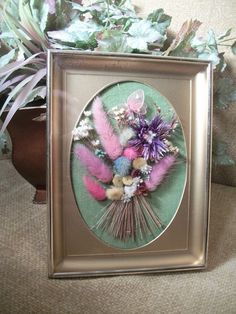 there is a picture frame with some flowers in it