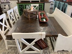 a wooden table with white chairs around it