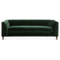 a green velvet couch with wooden legs