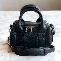 * Some Wear On Edges And Top Handle, Good Condition! * Two Inner Pockets, One Zip, One Flat Open * Base Length: 8.25 In * Height: 5.25 In * Width: 5.5 In * Silver-Tone Hardware * Crossbody Style Silver Hardware, Alexander Wang, Top Handle, Rocky, Black Silver, Alexander, Silver Tone, Bag Lady, Silver