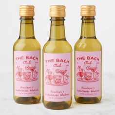 three bottles of the bach club cider vinegar on a marble countertop with gold caps