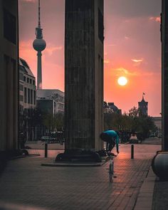 a person on a bike in the middle of a city street at sunset or dawn