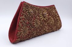 "Add instant glamour and elegance to any evening ensemble with this stunningly beautiful rich burgundy red silk evening bag clutch, intricately hand embroidered by zardozi artisans with copper metallic flowers and embellished with genuine star rubies to create an opulent, sophisticated 3D effect. Such rare artistry and craftsmanship! This is an exclusive piece, a wardrobe investment piece, a modern heirloom. More than fashion, it is an object d'art, inspired by the legacy of royalty. Zardozi mea Embroidered Clutch Evening Bag For Formal Events, Rectangular Gold Embroidered Evening Bag For Receptions, Party Bag With Resham Embroidery, Rectangular Shape, Evening Clutch With Resham Embroidery Rectangular, Formal Clutch Bags With Intricate Embroidery, Evening Clutch With Resham Embroidery, Formal Clutch With Intricate Embroidery, Designer Embroidered Clutch For Formal Occasions, Rectangular Embroidered Bag For Receptions