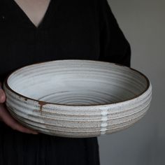 a person holding a white bowl in their hands