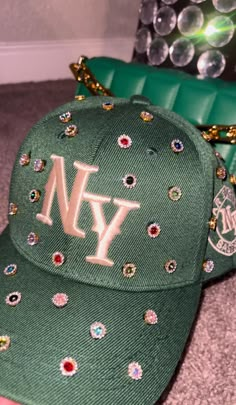 Adjustable NY Custom Bedazzled Hat customed by ShanayCosmetics Comes in 2 colors: Black or Green More colors COMING SOON....  PLEASE KEEP IN MIND THAT I AM NOT RESPONSIBLE FOR ANY DELAYS WITH SHIPPING ONCE I HAVE DROPPED YOUR PACKAGE OFF AT THE POST OFFICE! THAT IS OUT OF MY CONTROL. PLEASE BE AWARE I AM NOT RESPONSIBLE FOR ANY LOST, DAMAGED OR STOLEN PACKAGES!! Fitted Hats With Name, Custom Fitted Hats Drawings, Custom Fitted Hats Macy's, Bling Baseball Caps For Women, Cheap Fitted Costume Hats And Headpieces For Parties, Cheap Fun Customizable Hats, Luxury Custom Black Hat, Luxury Fitted Mini Hats For Parties, Luxury Rhinestone Hats With Curved Brim