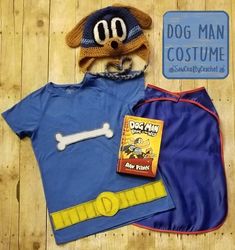 there is a dog man costume on the floor next to a shirt and hat with a book