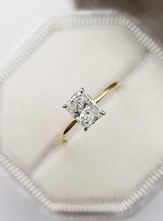 an engagement ring in a white box with a diamond on it's center stone