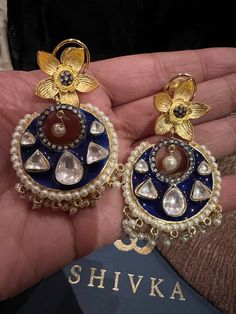 These gorgeous earrings will add a perfect charm to your occasion wear. You will definitely fall in love with this beauty and it will make you stand out among the crowd. Length: 6.5 cms Width: 3.5 cms One of a kind. The uncut Kundan stones embellished on a blue meenakari (enameled) base with pearl drop clusters make it a statement pair. The earrings are the same as shown in the pictures. We have only one piece in this design and color, hence you get what you see in the pictures. Festive Fusion Style Round Hoop Earrings, Wedding Hoop Earrings With Intricate Design, Fusion Style Pearl Earrings With Meenakari For Celebration, Fusion Style Meenakari Pearl Earrings For Celebrations, Fusion Pearl Earrings With Meenakari For Celebrations, Fusion Style Pearl Earrings With Latkans For Celebrations, Festive Fusion Hoop Earrings For Celebration, Chandbali Fusion Hoop Earrings For Celebration, Fusion Style Chandbali Hoop Earrings For Celebration