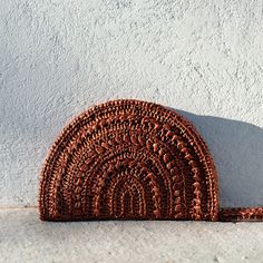 "The Raffia Moon Clutch - a crochet clutch bag, delicately handcrafted with luxurious Italian 100% viscose raffia yarn. Fully lined with thick cotton, features an inner pocket, zip closure, and a crochet raffia wristlet. Handcrafted in Greece. DETAILS * Premium quality Italian 100% viscose raffia * Hand-crocheted with care * Width: 27cm (10.7\"), Height: 18cm (7\") * Fully lined with thick cotton * Bronze metal zipper * Inner pocket * Crochet raffia wristlet COLORS & CARE * Available in Rust Handmade Brown Handheld Clutch, Bohemian Handmade Brown Pouch, Handmade Bohemian Brown Pouch, Brown Handheld Clutch For Beach, Handmade Brown Pouch For Beach, Handmade Brown Clutch For Vacation, Bohemian Brown Woven Clutch, Bohemian Brown Pouch Clutch, Pocket Crochet