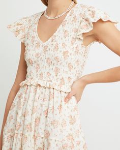 Price Comparison Few Moda $74 Sea $395 Love the Label $275 Product Details Ruffled cap sleeves and flowy skirt add effortlessness to this sweet style. Done with a smocked bodice and V-neckline.- Back zipper- Smocked bodice- Pockets- Content: 100% Cotton Style# T21WDR00302 Fit Notes - Model wearing a size XS- Model measurements: 5'10'' Height / 32'' Bust / 24'' Waist / 34'' Hips - Garment measurements may vary due to the smocking bodice: Size Length Bust Waist XS 130 66 - 76 52 - 57 S 131.5 70 - Spring V-neck Smocked Dress For Day Out, Fitted V-neck Smocked Summer Dress, Spring Dresses With Smocked Bodice And Ruffle Sleeves, Feminine Smocked Dress With Flutter Sleeves For Spring, Spring V-neck Smocked Dress For Daywear, Flowy V-neck Smocked Dress, Chic V-neck Smocked Dress With Ruffles, Summer V-neck Dress With Smocked Bodice, Chic Fitted V-neck Smocked Dress