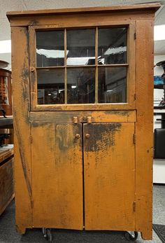 an old wooden cabinet sitting on wheels in a room