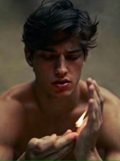 a man holding a lit candle in his hands