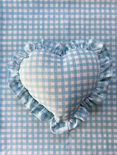 a blue and white checkered pillow with a heart shaped ruffle on the front