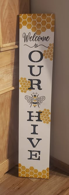 a welcome sign with the words queen bee on it next to a wooden door frame