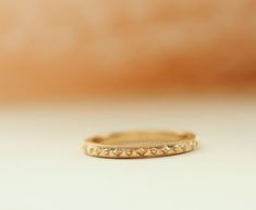 Cherished Gold Ring
With a delicate confetti beaded pattern surrounding the entire band, she's a reminder you're cherished. You cherish those you love most.  Beautiful crafted stacking ring perfectly pairs with other Erin Pelicano rings, or as a band worn in her own beauty. Stack one for each child, stack one for each of your favorite people, collect one for each milestone, or wear as your wedding band.

Designed and crafted in solid 14k gold, choose from white, yellow, or rose gold.

 	14k Heirloom Stackable Eternity Band As Gift, Fine Jewelry Stackable Promise Rings With Decorative Band, Fine Jewelry Stackable Decorative Band Rings For Promise, Adjustable Heirloom Stackable Rings, Handmade 14k Gold Stackable Promise Rings, Stackable Promise Rings With Decorative Band, Heirloom Style Stackable Bands As A Gift, Heirloom Stackable Rings With Decorative Band, Heirloom Style Stackable Bands As Gift