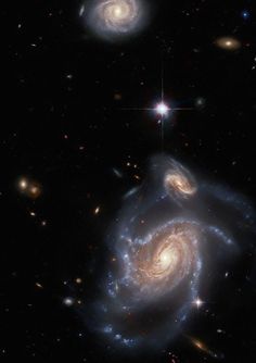 two spiral galaxy like objects in the dark sky