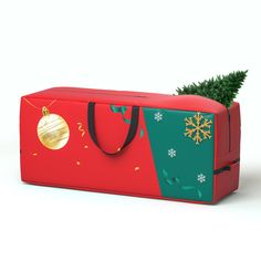 a christmas present bag with a small tree in the bottom and gold ornament hanging from it