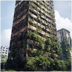 a tall building covered in lots of green plants