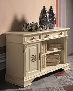 two vases sitting on top of a white cabinet